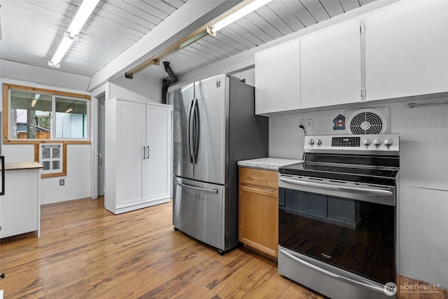 kitchen featuring visible vents, light wood finished floors, light countertops, appliances with stainless steel finishes, and beamed ceiling