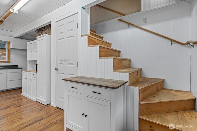 stairway with beam ceiling and wood finished floors