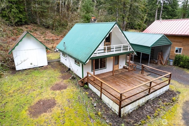 back of property with metal roof, an outbuilding, and a storage shed