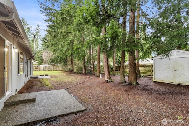 view of yard featuring an outdoor structure, a fenced backyard, a patio, and a storage shed
