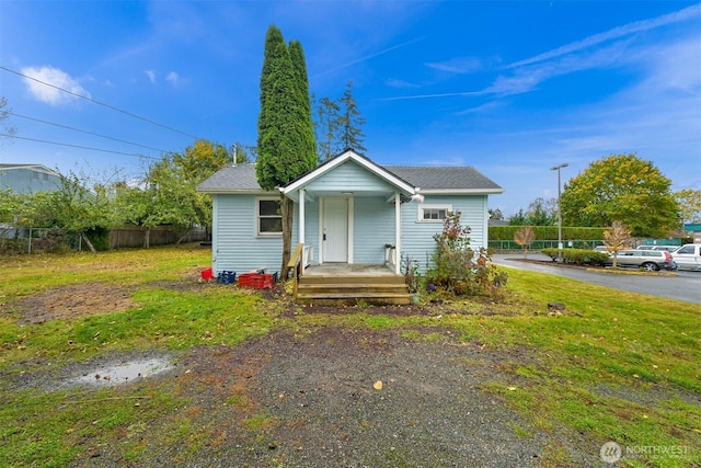 bungalow-style house with a porch, a front yard, and fence