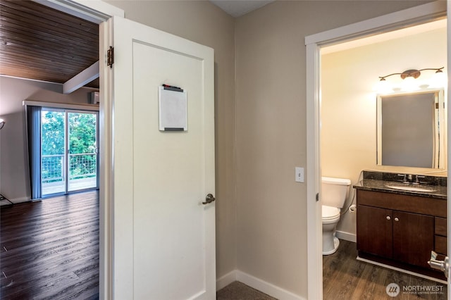 600 Harrison St, Friday Harbor, WA 98250 - half bathroom featuring vanity, toilet, wood finished floors, and baseboards