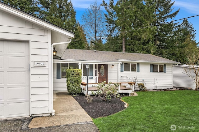 view of front of house featuring a front yard, a porch, roof with shingles, and an attached garage