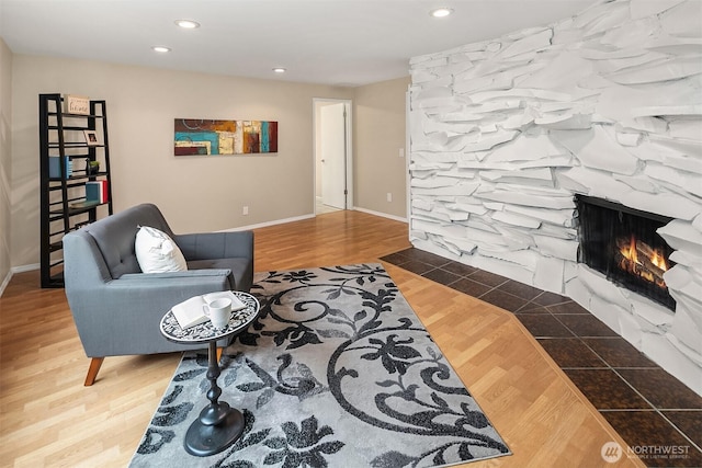 living area with recessed lighting, a fireplace, baseboards, and wood finished floors