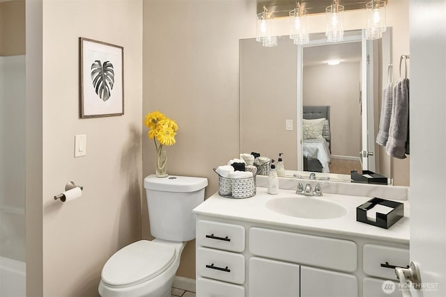 ensuite bathroom with vanity, ensuite bath, and toilet