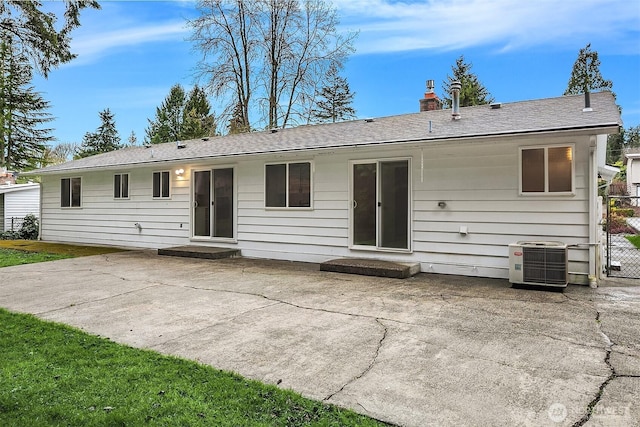 rear view of property featuring fence, central AC unit, a chimney, and a patio area