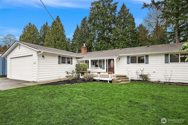 back of house with a yard, a garage, and a chimney