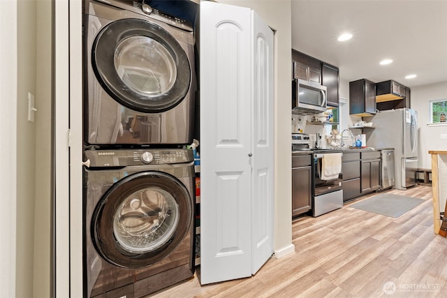 washroom featuring laundry area, recessed lighting, a sink, light wood-style floors, and stacked washer and clothes dryer