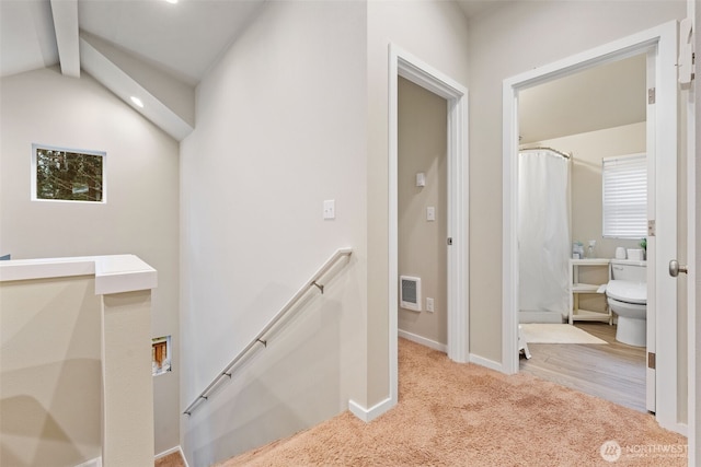 hall featuring visible vents, an upstairs landing, lofted ceiling with beams, carpet, and baseboards