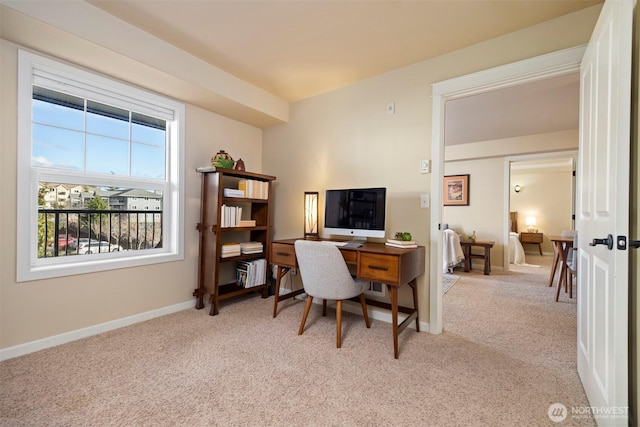 office space featuring baseboards and light carpet