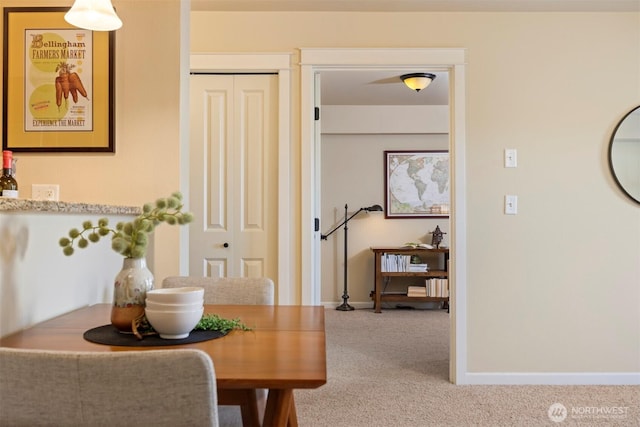 carpeted dining area featuring baseboards