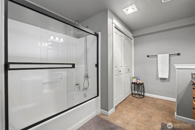 full bath with tile patterned floors, baseboards, and bath / shower combo with glass door