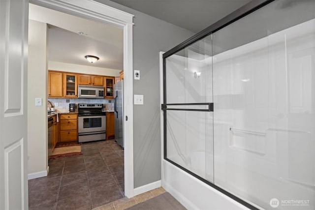 full bath with decorative backsplash, baseboards, and tile patterned flooring