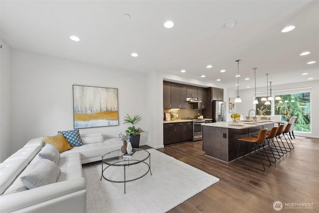 living room featuring recessed lighting and dark wood-style floors