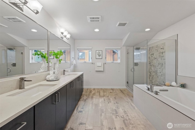 bathroom with a shower stall, visible vents, and a sink