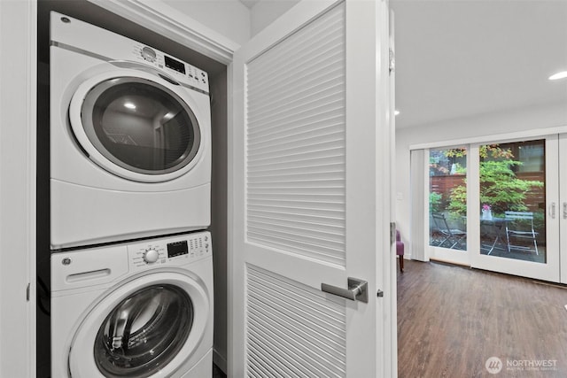 laundry area featuring recessed lighting, wood finished floors, laundry area, and stacked washing maching and dryer