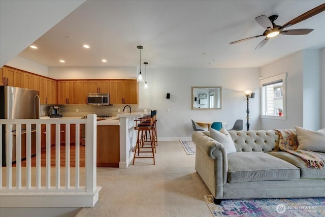 living room with light carpet, recessed lighting, baseboards, and ceiling fan