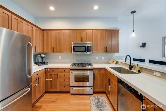 kitchen featuring tasteful backsplash, brown cabinets, stainless steel appliances, and a sink