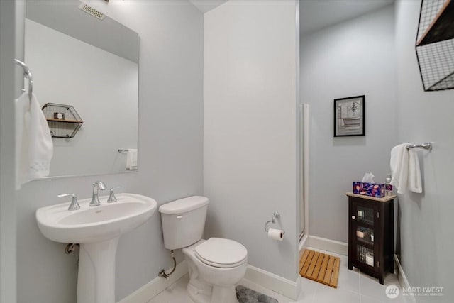 full bathroom featuring tile patterned floors, visible vents, toilet, a shower stall, and baseboards