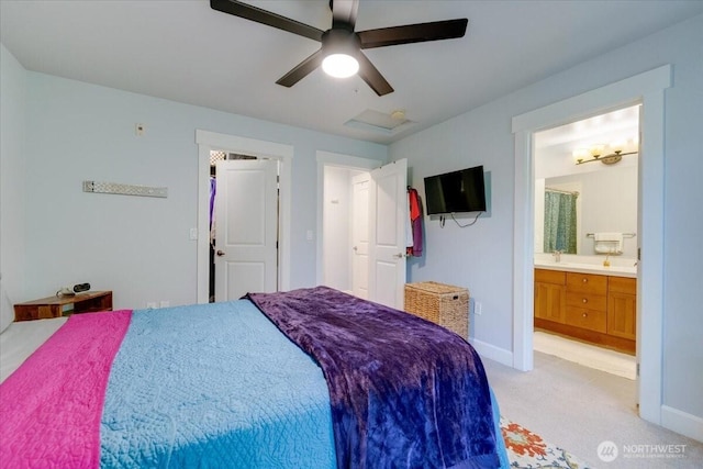 bedroom with attic access, light colored carpet, baseboards, and ensuite bathroom