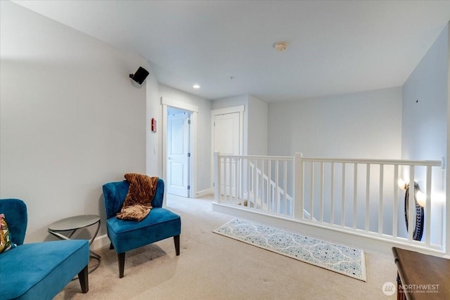 sitting room with recessed lighting, an upstairs landing, baseboards, and carpet floors