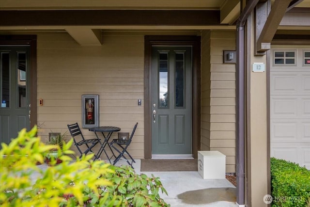 doorway to property featuring a porch and a garage