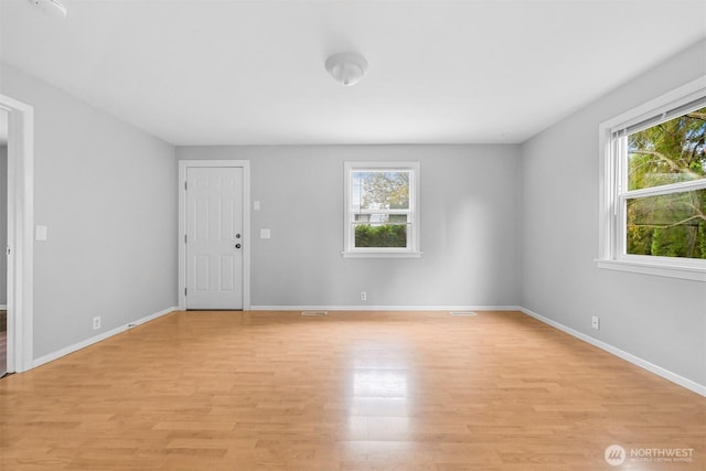 empty room featuring light wood-style flooring and baseboards