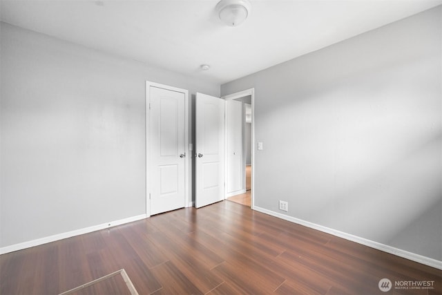 unfurnished bedroom featuring wood finished floors and baseboards