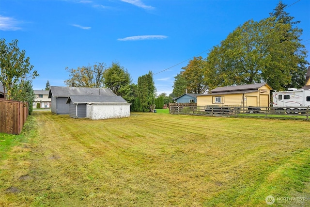 view of yard with an outdoor structure and fence