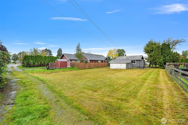 view of yard featuring an outbuilding and fence