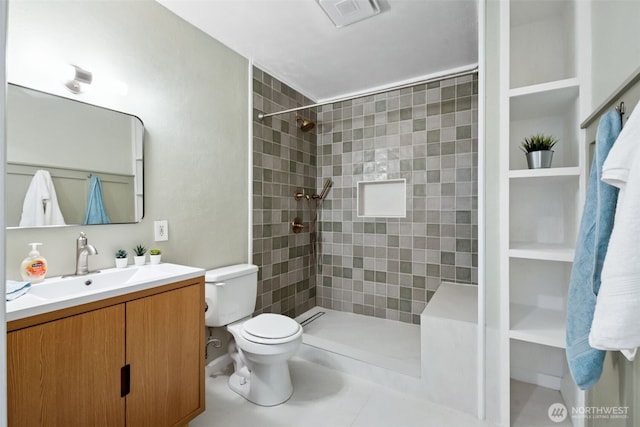 full bathroom featuring vanity, toilet, visible vents, and tiled shower