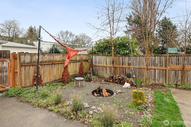 view of yard featuring a fire pit and a fenced backyard