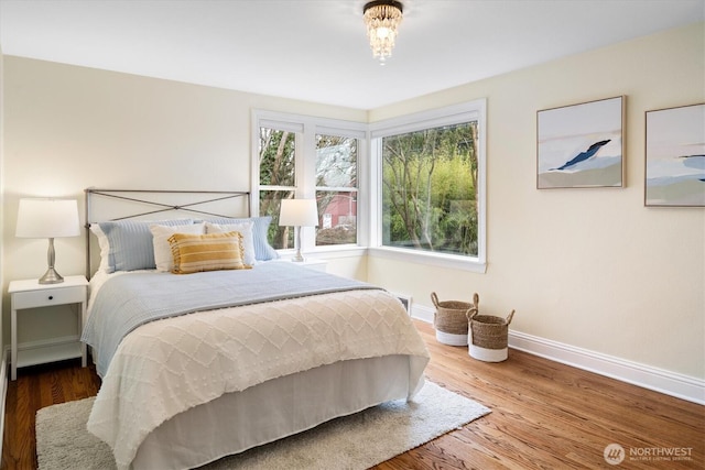 bedroom with baseboards and wood finished floors