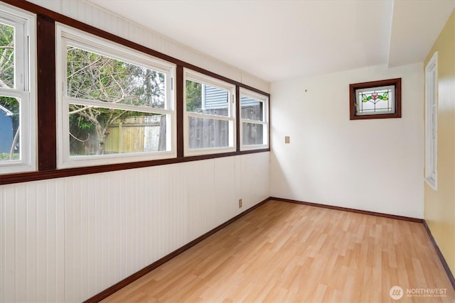 empty room featuring baseboards and light wood finished floors