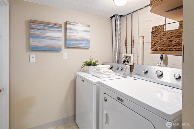 clothes washing area featuring washing machine and clothes dryer and laundry area