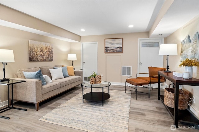 living area with light wood-style flooring, recessed lighting, visible vents, and baseboards