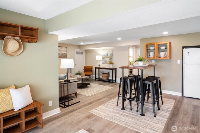 dining room with recessed lighting, light wood-style floors, and baseboards