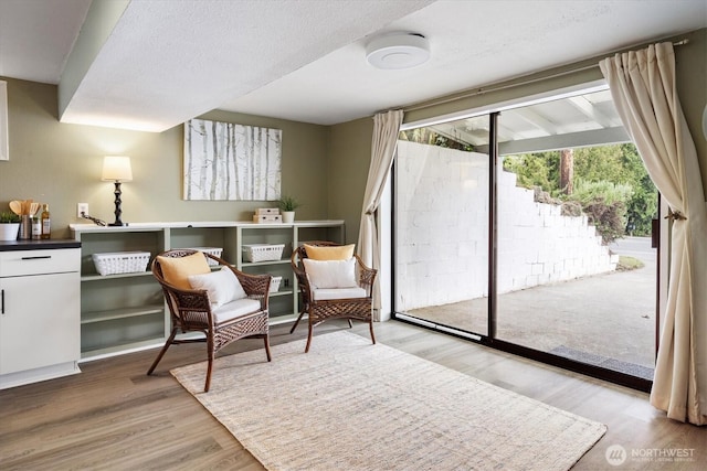 living area featuring a textured ceiling and wood finished floors