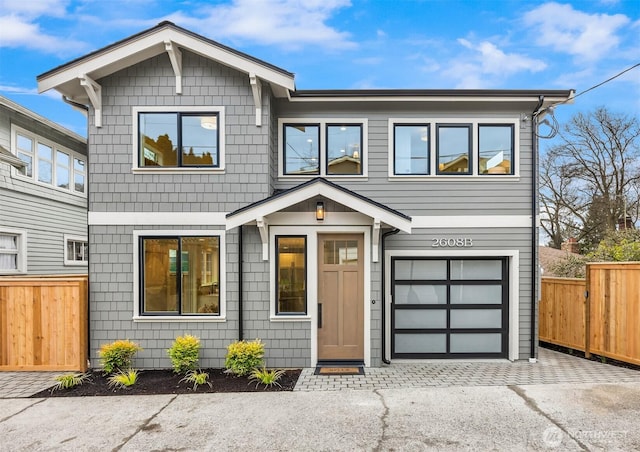 view of front of home featuring an attached garage, driveway, and fence