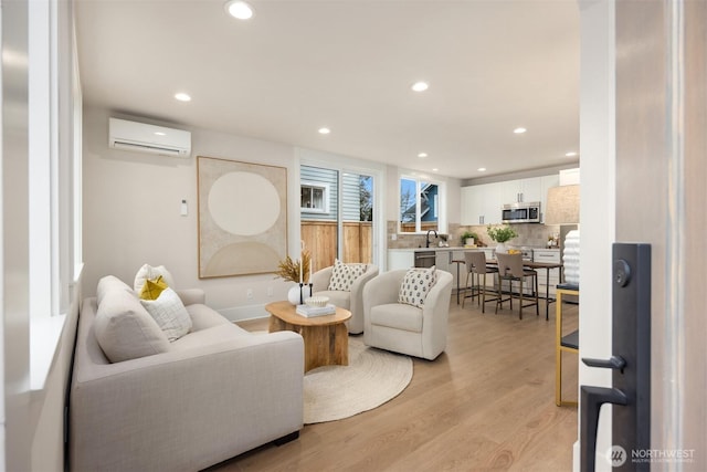 living area featuring a wall unit AC, recessed lighting, and light wood-type flooring