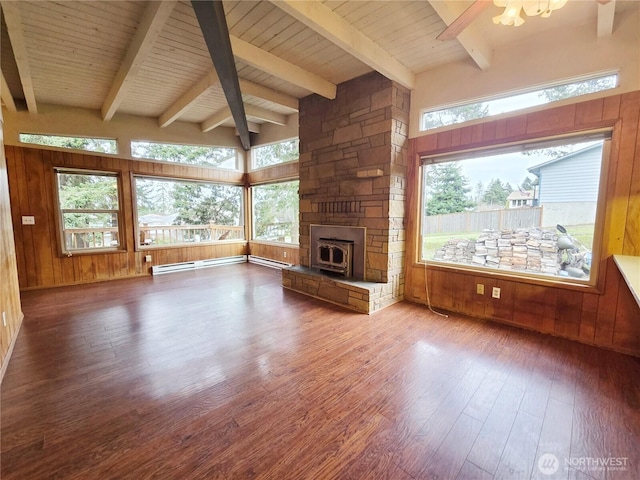 unfurnished living room with beam ceiling, wooden walls, wooden ceiling, and wood finished floors