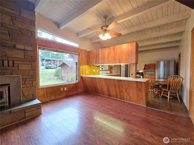 kitchen featuring light countertops, brown cabinetry, dark wood-style flooring, and appliances with stainless steel finishes