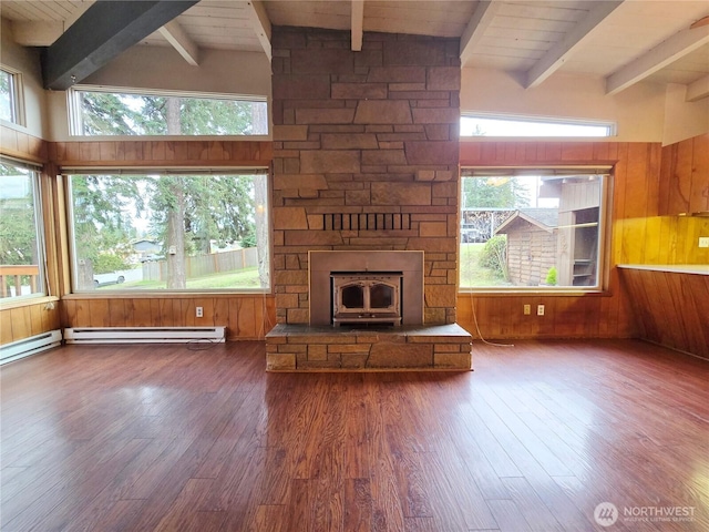 unfurnished living room featuring a wealth of natural light, a baseboard heating unit, and wood finished floors