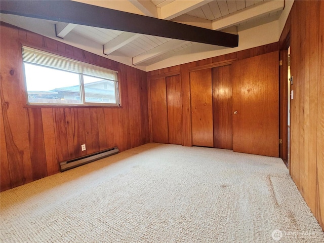 carpeted spare room featuring a baseboard heating unit, wood walls, and vaulted ceiling with beams