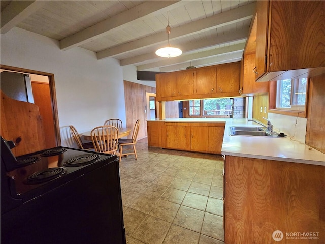 kitchen with black range with electric stovetop, beamed ceiling, light countertops, brown cabinetry, and a sink