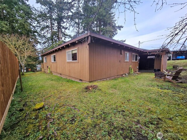 view of side of property featuring a lawn and fence