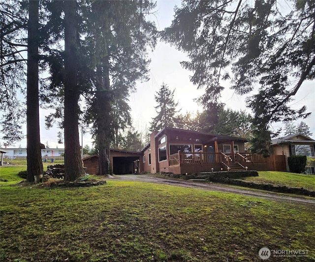 view of front of home with an attached carport, a front lawn, driveway, and a chimney