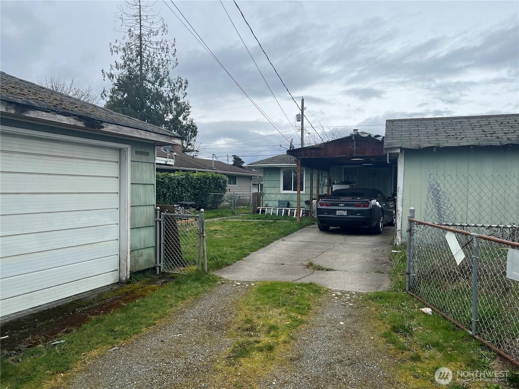 view of home's exterior featuring a carport, driveway, a gate, and fence