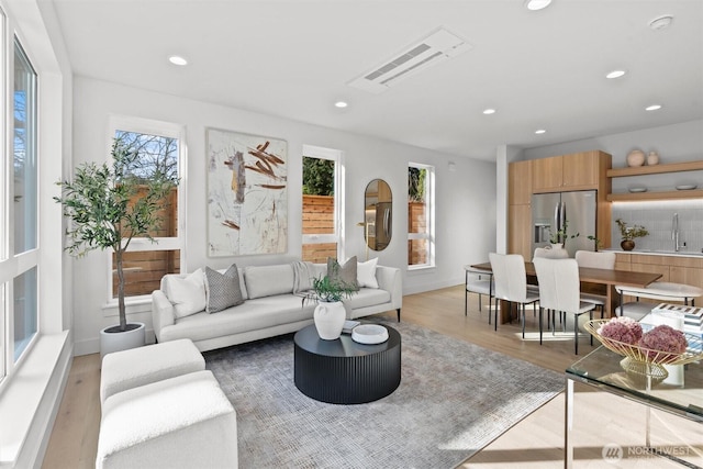 living room with visible vents, recessed lighting, baseboards, and light wood-style floors