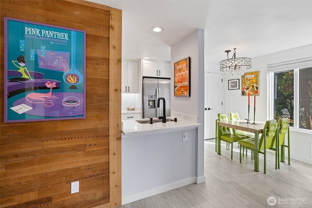 hall with baseboards, recessed lighting, a sink, light wood-style floors, and a notable chandelier